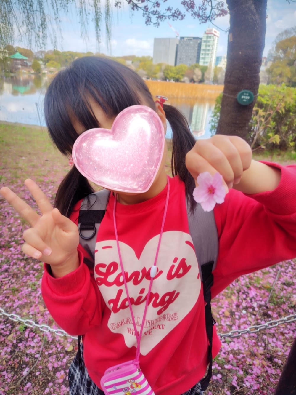 ブラック系のスウェット、ブルー系のデニムパンツ、ブルー系のスニーカーを着用したレディースの春コーディネートの2枚目の写真