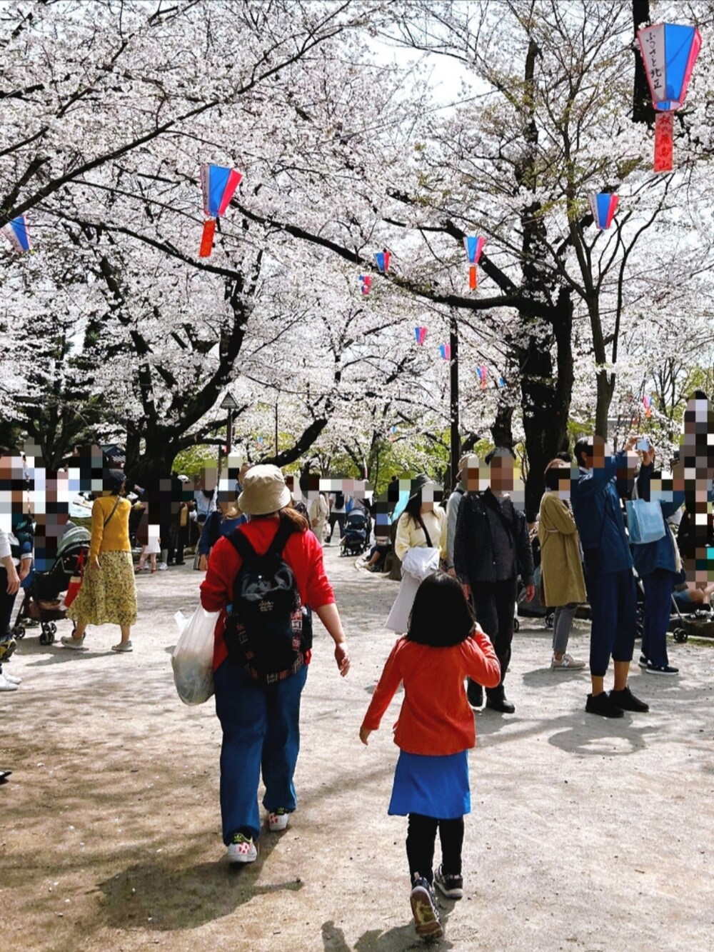 レッド系のTシャツ/カットソー、ブルー系のデニムパンツ、ホワイト系のスニーカーを着用したレディースの春コーディネートの3枚目の写真