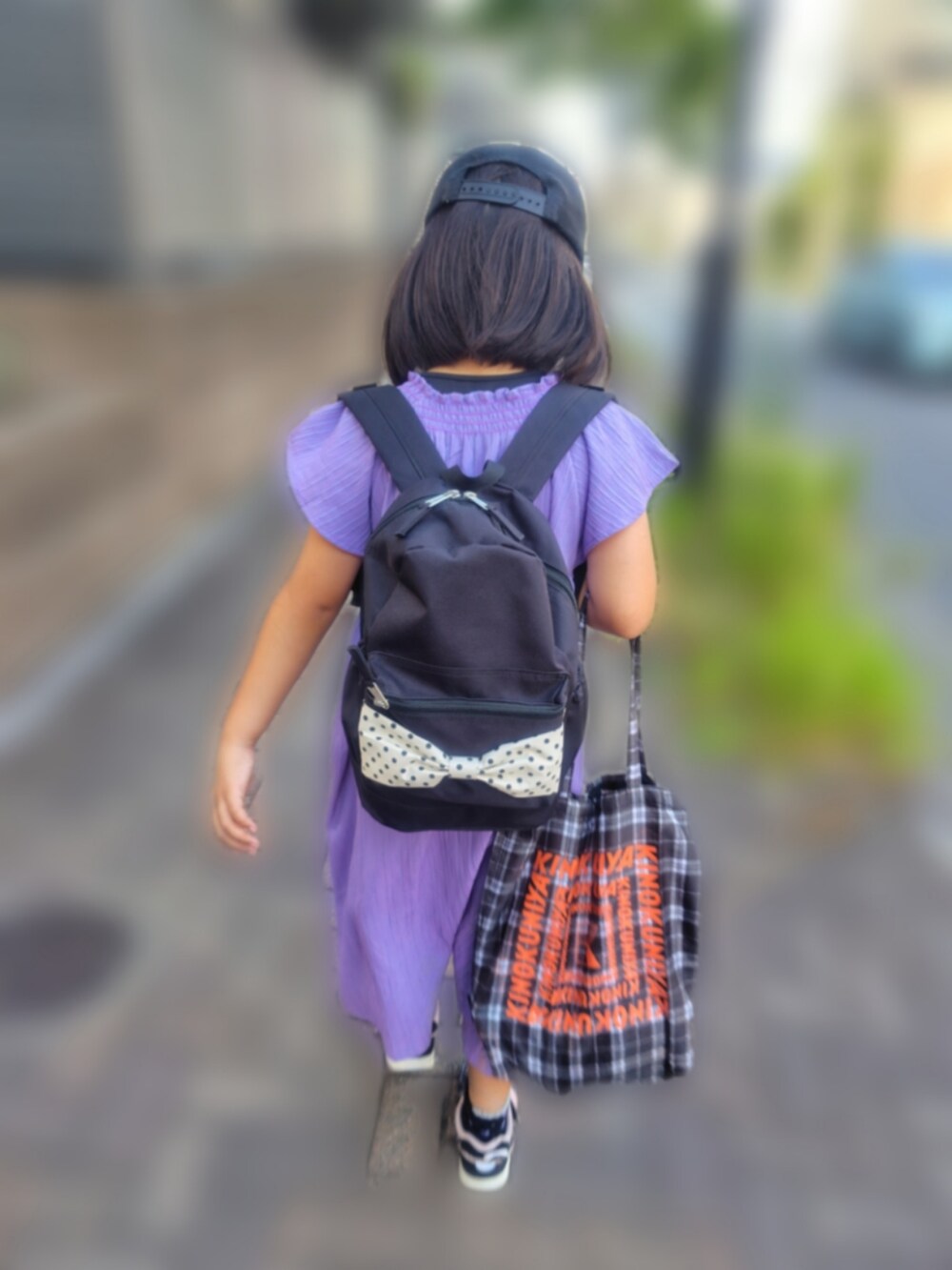 レッド系のワンピース、その他のトートバッグ、ブルー系のデニムパンツを着用したレディースの夏コーディネートの2枚目の写真