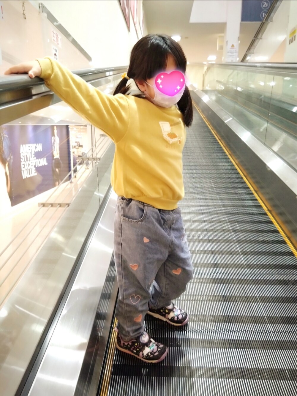 ベージュ系のスウェット、ブルー系のデニムパンツ、レッド系のスニーカーを着用したレディースの冬コーディネートの2枚目の写真