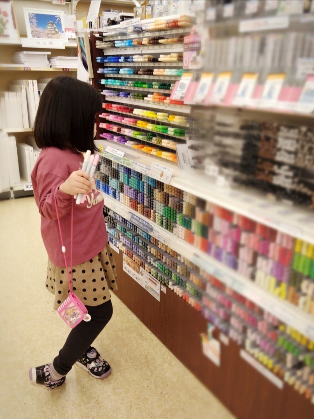 レッド系のマウンテンパーカー、その他のTシャツ/カットソー、ブラック系のスラックスを着用したレディースの春コーディネートの2枚目の写真