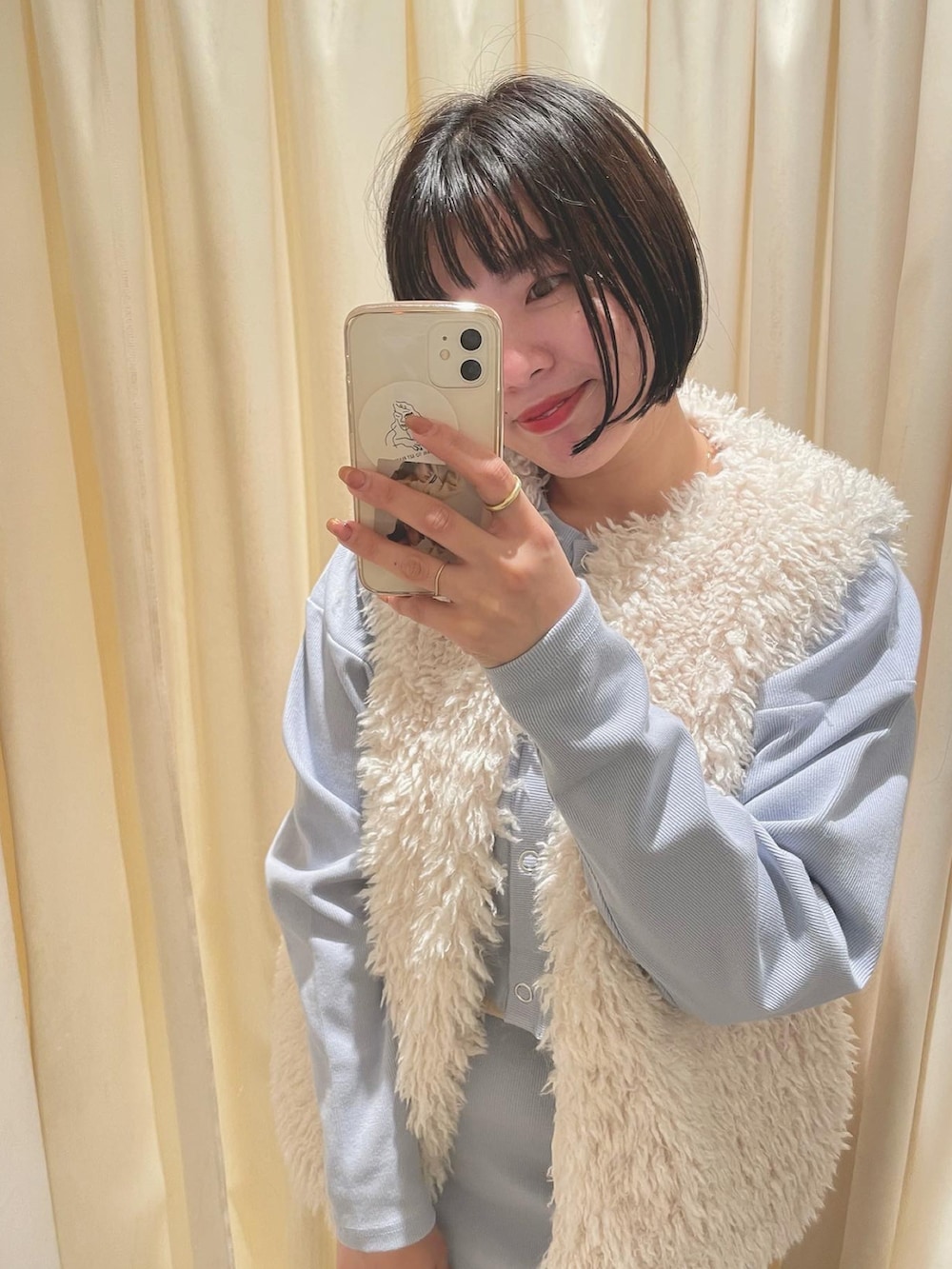 ブルー系のワンピース、ホワイト系のベストを着用したレディースの冬コーディネートの2枚目の写真