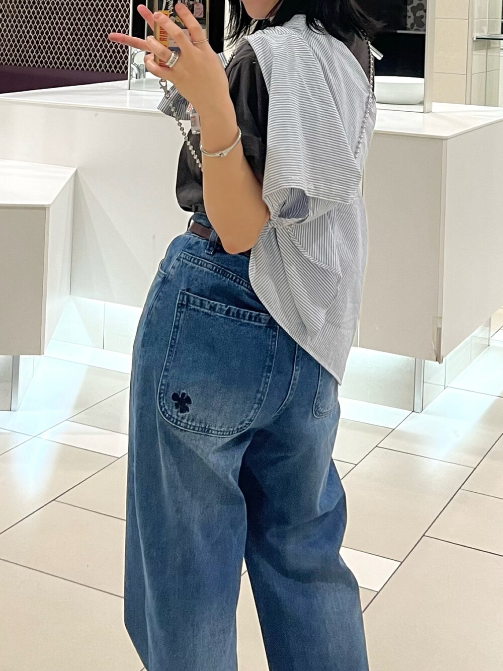 グレー系のTシャツ/カットソー、ブルー系のデニムパンツを着用したレディースの秋コーディネートの3枚目の写真