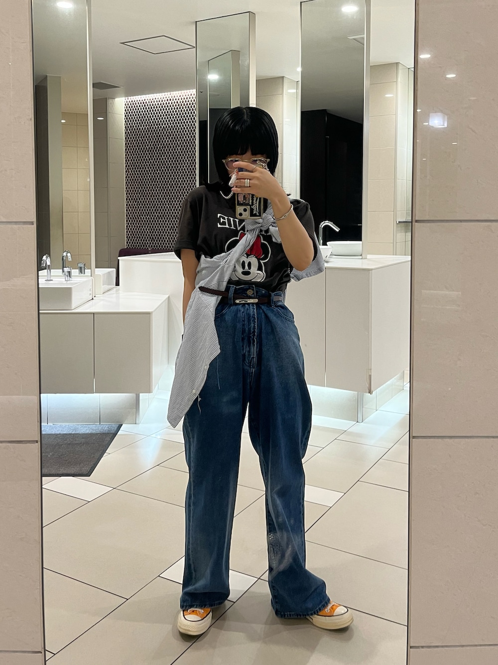 グレー系のTシャツ/カットソー、ブルー系のデニムパンツを着用したレディースの秋コーディネートの2枚目の写真