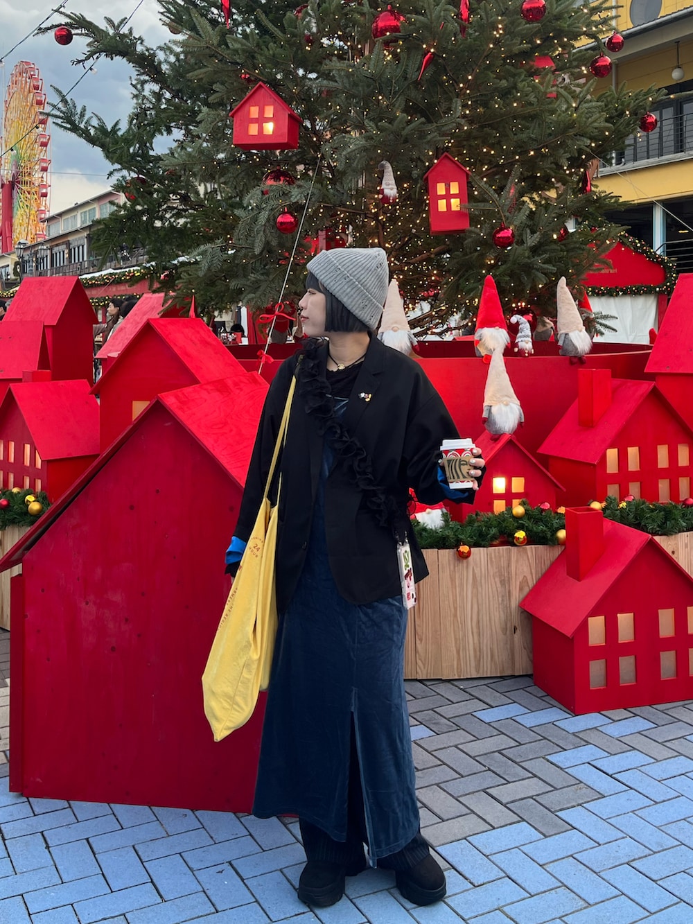 ブラック系のテーラードジャケット、イエロー系のトートバッグ、ブラック系のブーツを着用したレディースの冬コーディネートの2枚目の写真