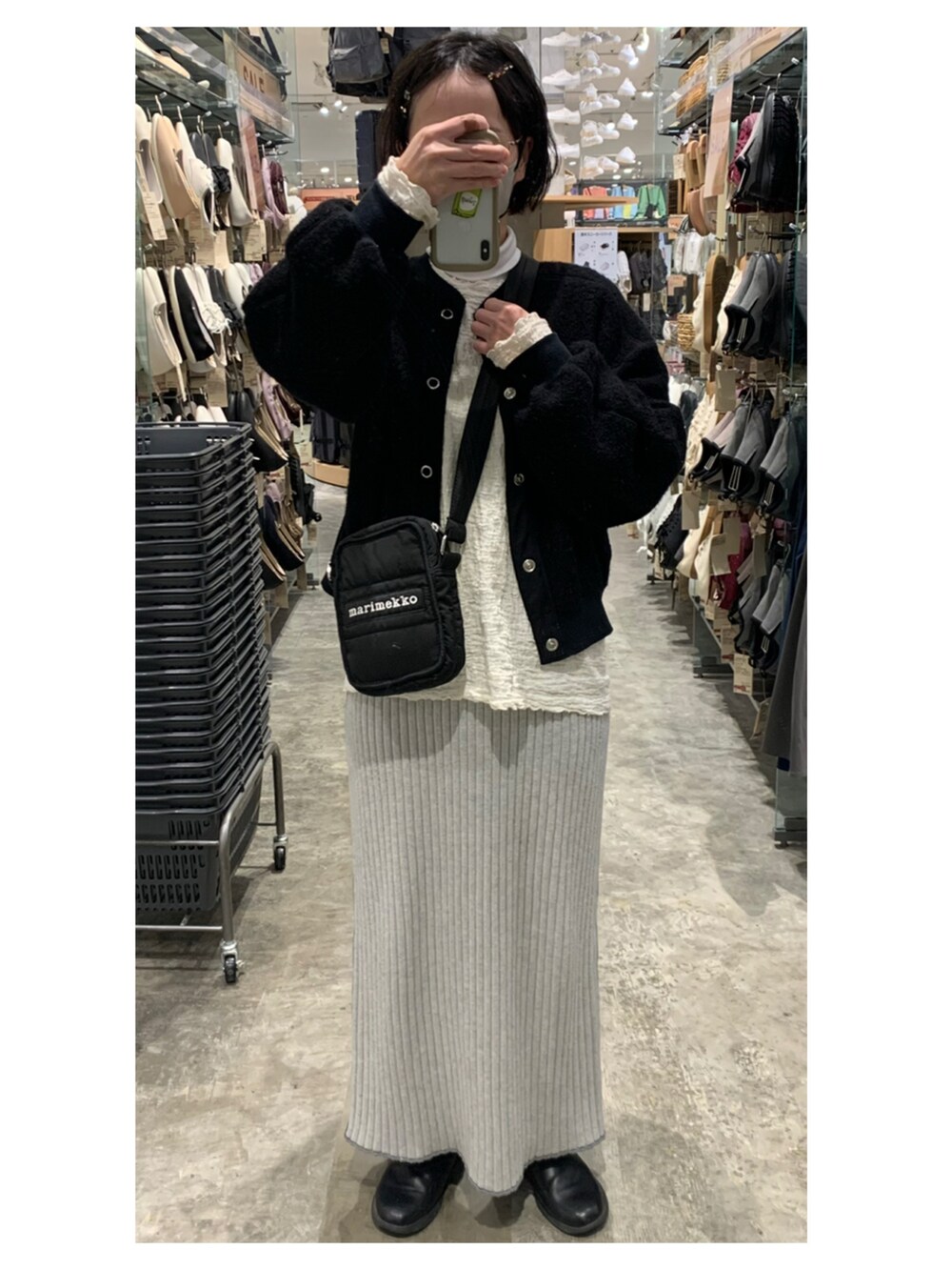 ホワイト系のシャツ/ブラウス、ブラック系のカーディガン/ボレロ、ブラウン系のかごバッグを着用したレディースの冬コーディネートの2枚目の写真