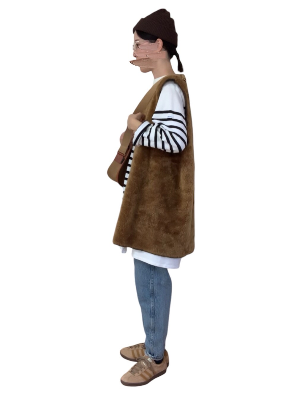 ブラック系のTシャツ/カットソー、ブラウン系のベスト、ベージュ系のバッグを着用したレディースの秋コーディネートの4枚目の写真