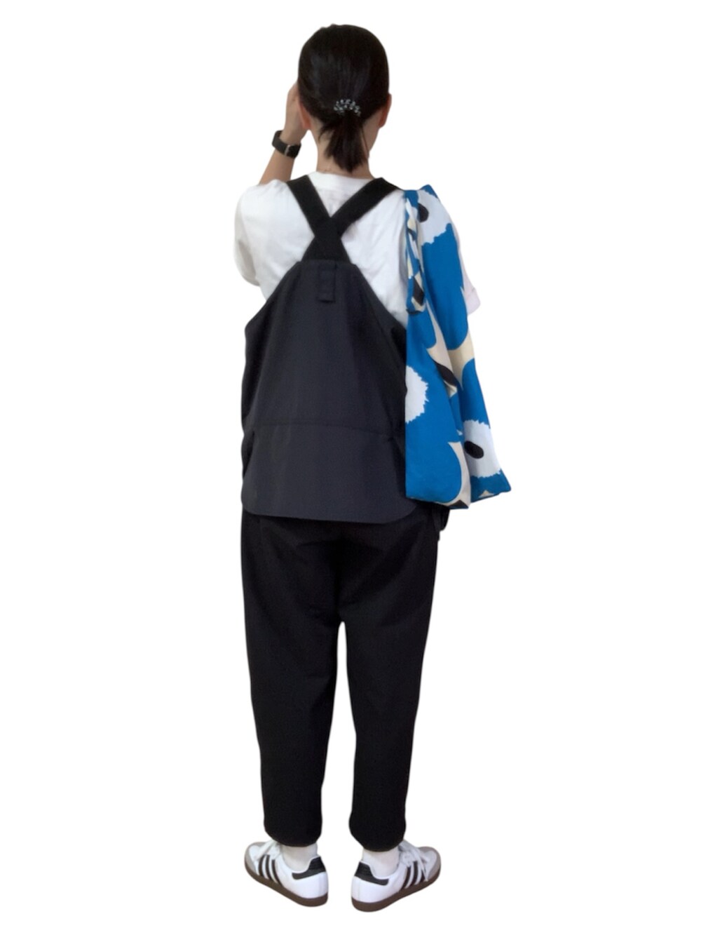 ホワイト系のTシャツ/カットソー、ブラック系のベスト、ホワイト系のスニーカーを着用したレディースの秋コーディネートの4枚目の写真