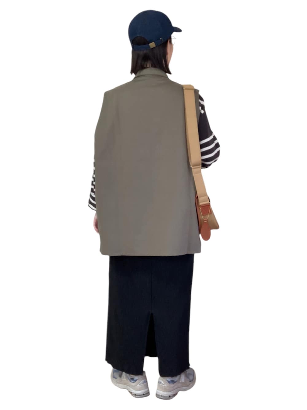 グリーン系のベスト、ブラック系のTシャツ/カットソー、ブラック系のスカートを着用したレディースの秋コーディネートの3枚目の写真