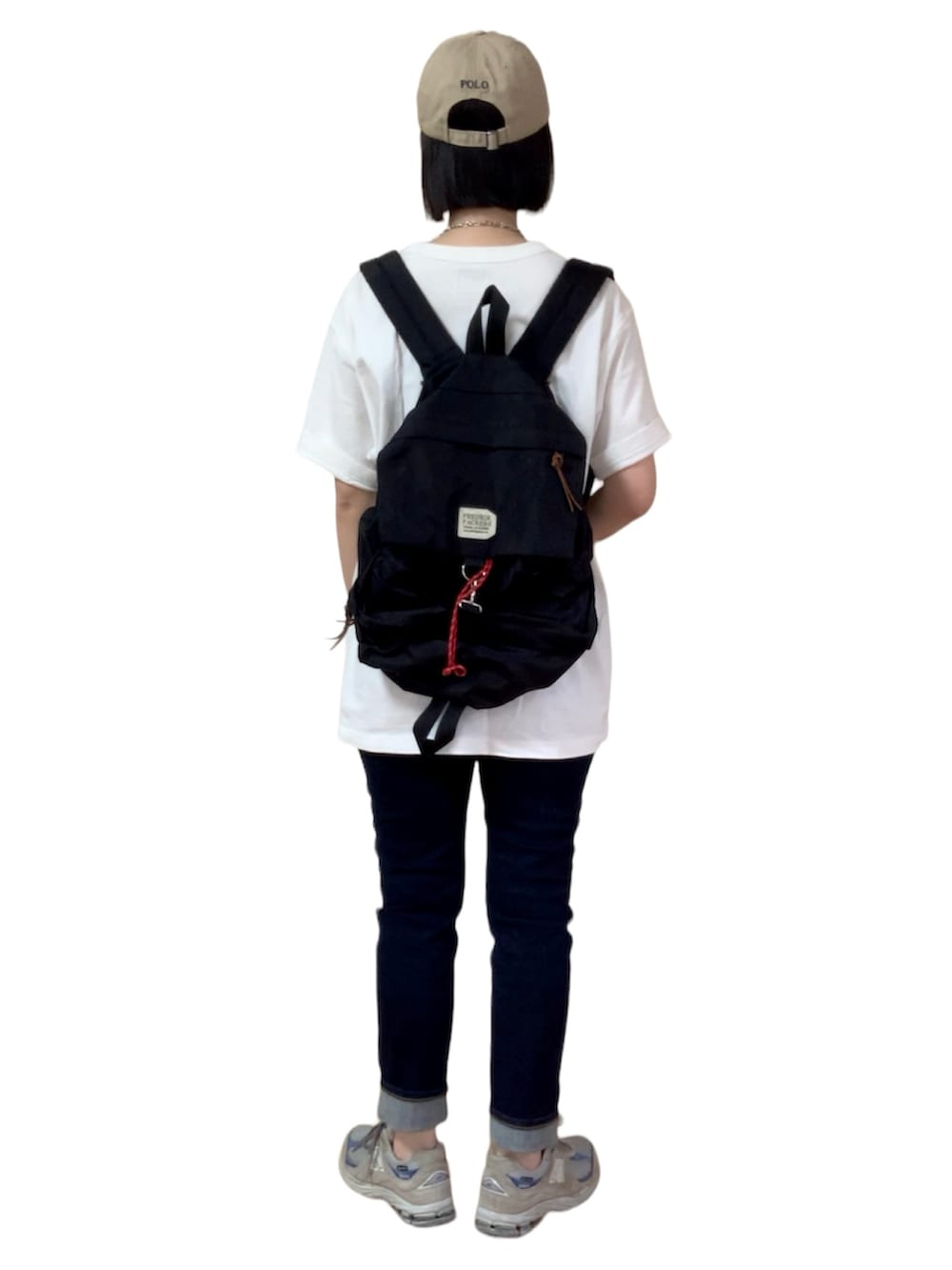 グレー系のデニムパンツ、グレー系のスニーカー、ベージュ系のキャップを着用したレディースの春コーディネートの3枚目の写真