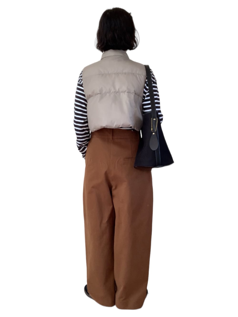 ベージュ系のベスト、レッド系のTシャツ/カットソー、ブラック系のショルダーバッグを着用したレディースの冬コーディネートの3枚目の写真