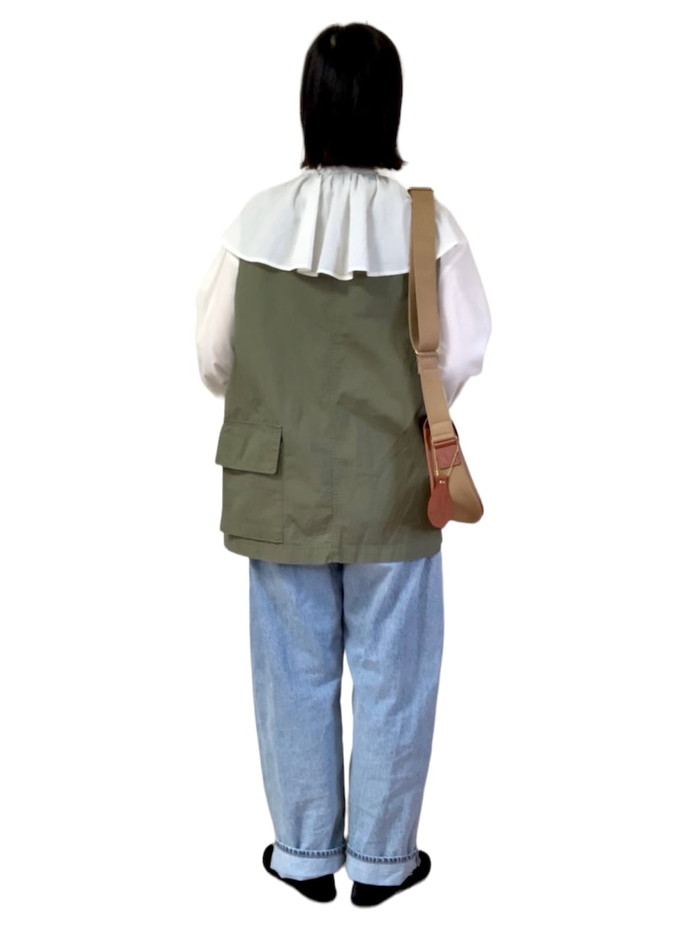 ホワイト系のシャツ/ブラウス、グリーン系のベスト、ブルー系のデニムパンツを着用したレディースの春コーディネートの2枚目の写真