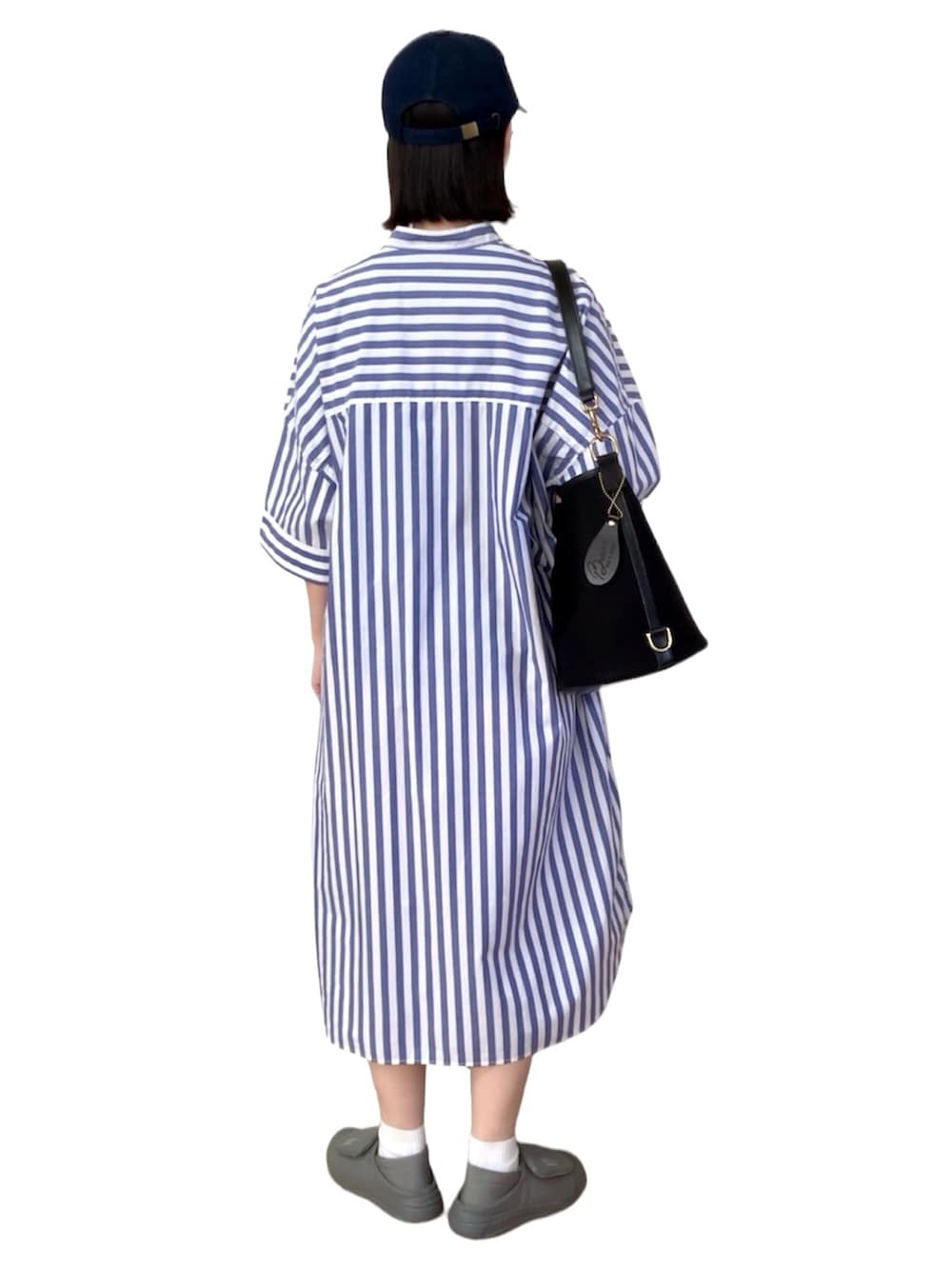 ブルー系のシャツワンピース、ブラック系のショルダーバッグ、ホワイト系のスニーカーを着用したレディースの夏コーディネートの2枚目の写真