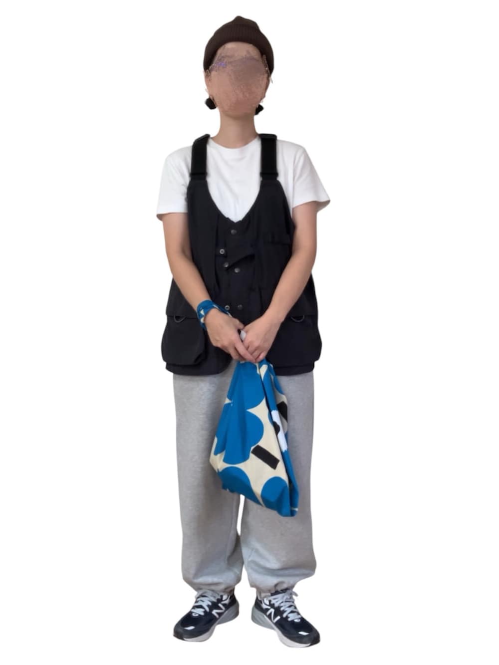 ブラック系のベスト、グレー系のスウェットパンツ、ブルー系のスニーカーを着用したレディースの秋コーディネートの2枚目の写真