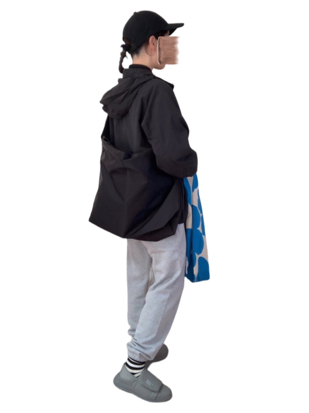 グレー系のスウェットパンツ、ブラック系のマウンテンパーカー、ブルー系のエコバッグ/サブバッグを着用したレディースの秋コーディネートの2枚目の写真