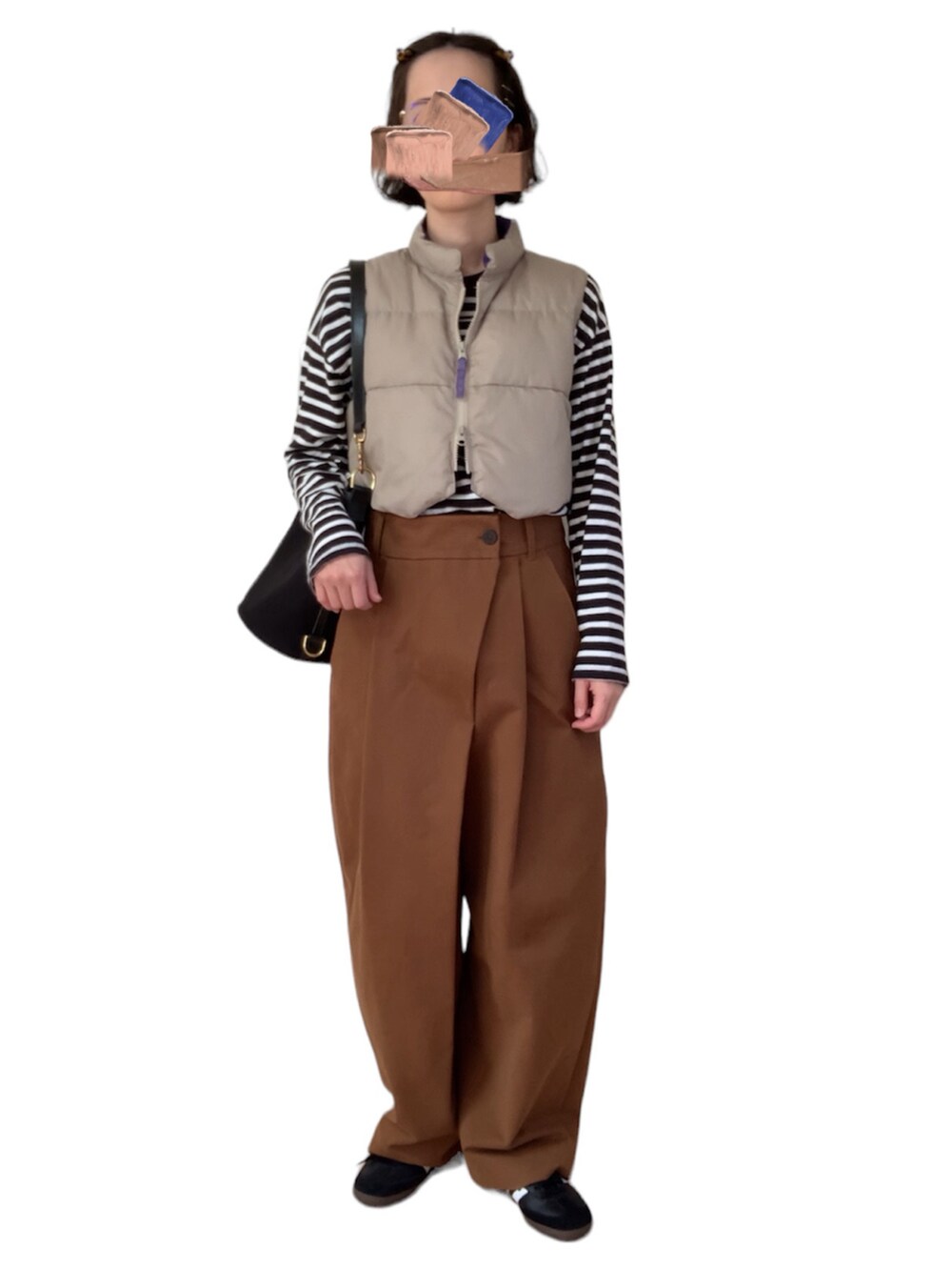 ベージュ系のベスト、レッド系のTシャツ/カットソー、ブラック系のショルダーバッグを着用したレディースの冬コーディネートの2枚目の写真