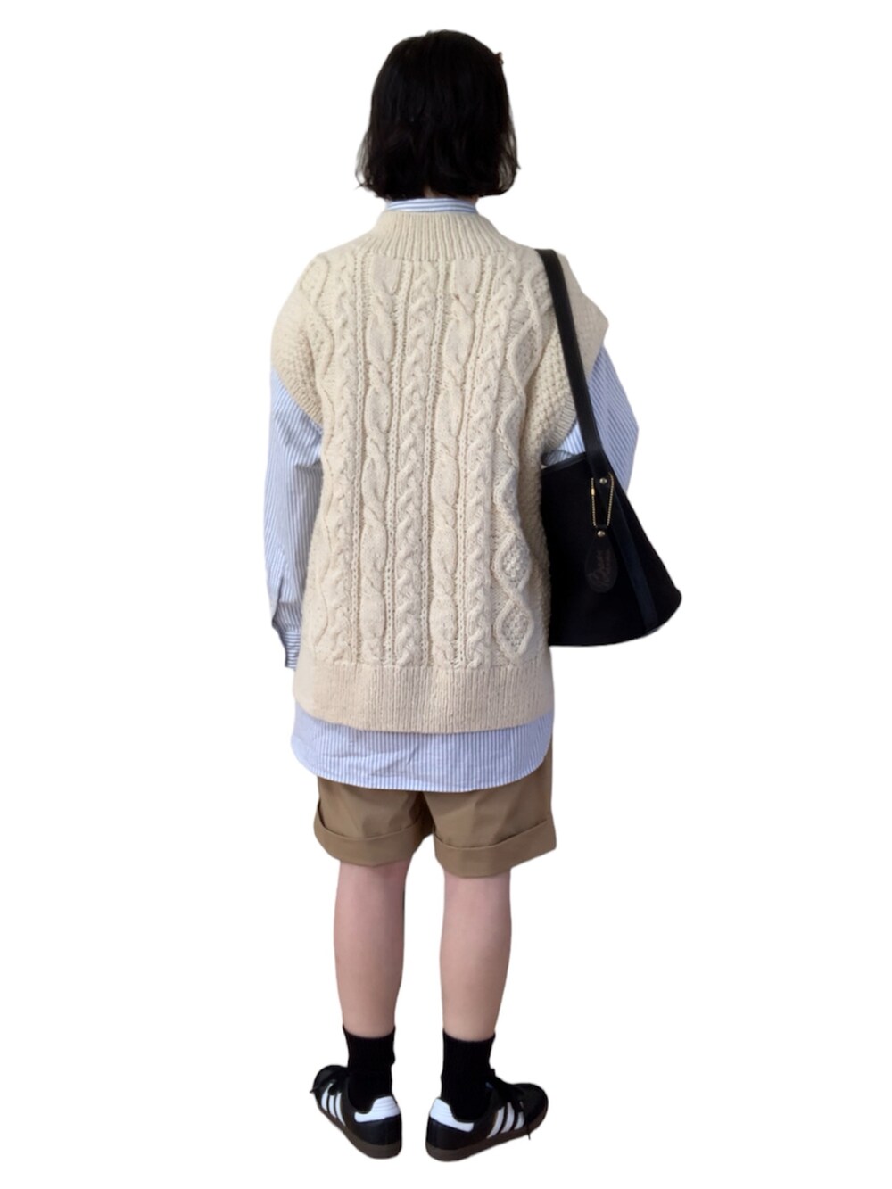 ホワイト系のベスト、ブルー系のシャツ/ブラウス、ブラック系のショルダーバッグを着用したレディースの冬コーディネートの2枚目の写真
