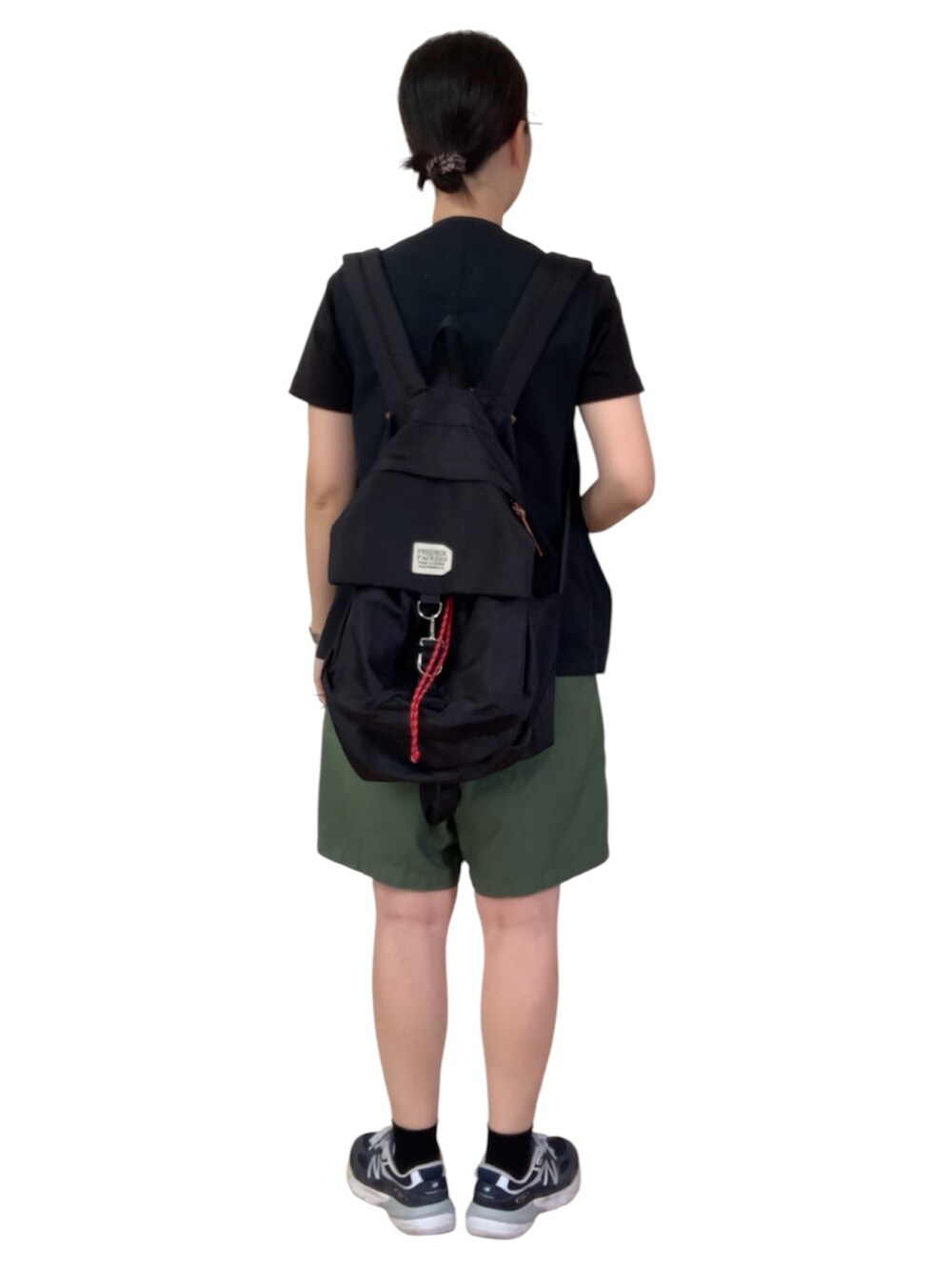 ブラック系のベスト、グリーン系のその他パンツ、ブルー系のスニーカーを着用したレディースの秋コーディネートの3枚目の写真