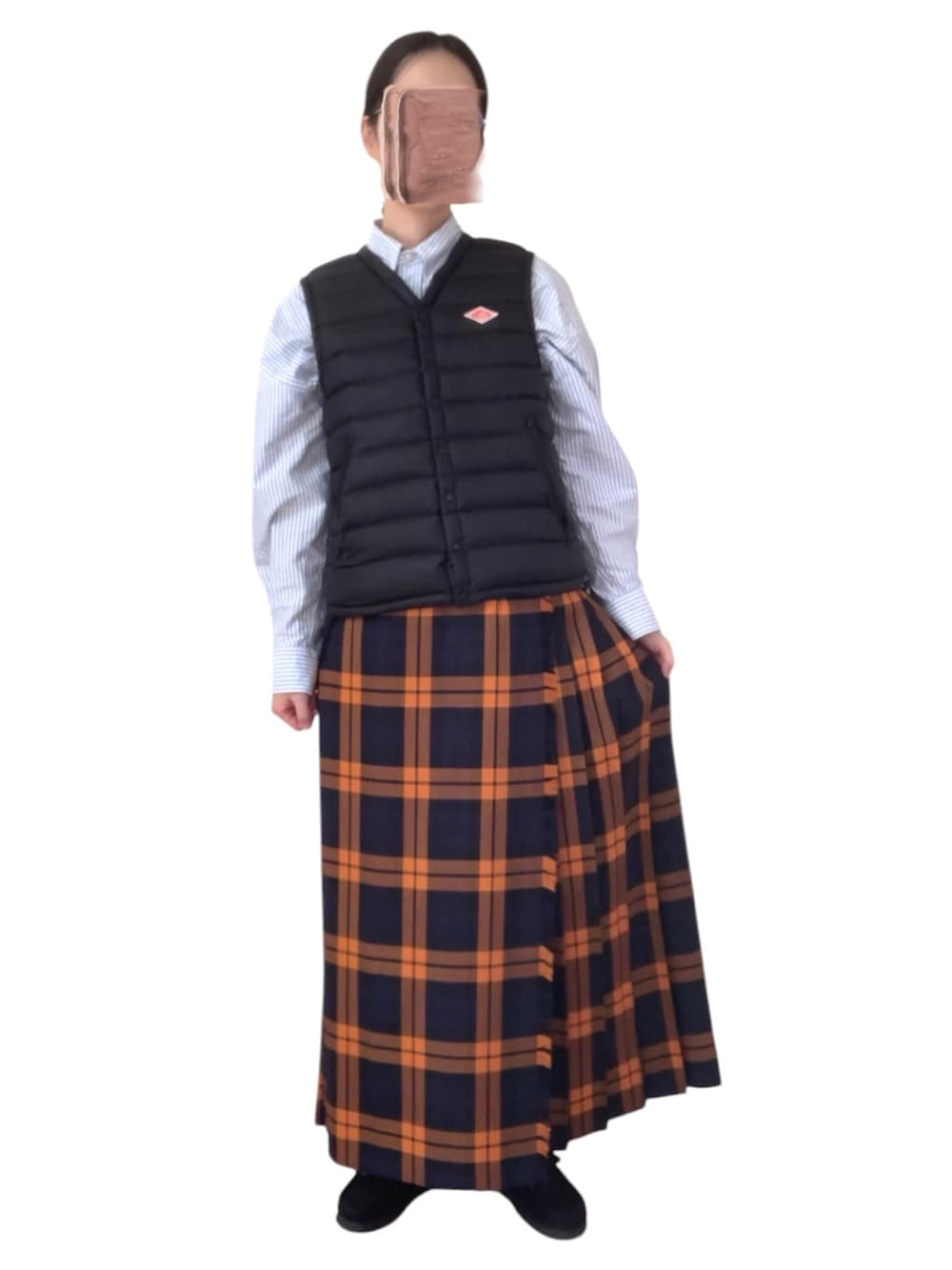 ブルー系のデニムジャケット、ブラック系のダウンベスト、オレンジ系のスカートを着用したレディースの冬コーディネートの5枚目の写真