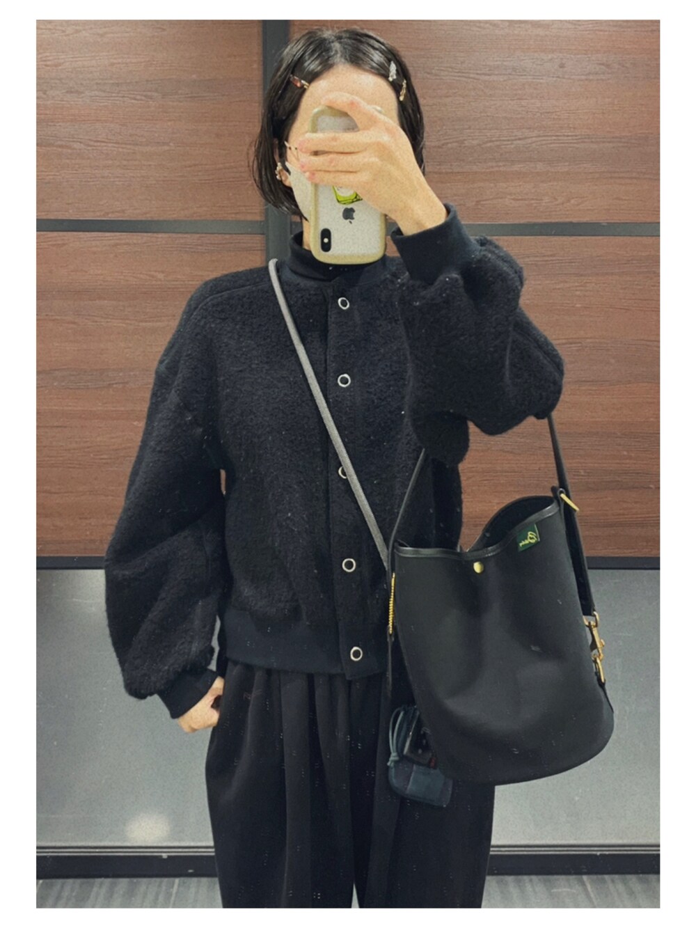 ホワイト系のシャツ/ブラウス、ブラック系のカーディガン/ボレロ、ブラウン系のかごバッグを着用したレディースの冬コーディネートの3枚目の写真