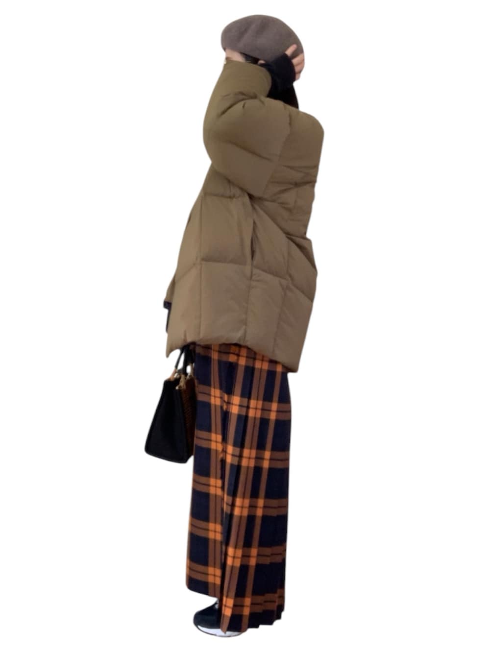 ブラウン系のダウンジャケット/コート、オレンジ系のスカート、ブラウン系のかごバッグを着用したレディースの冬コーディネートの2枚目の写真