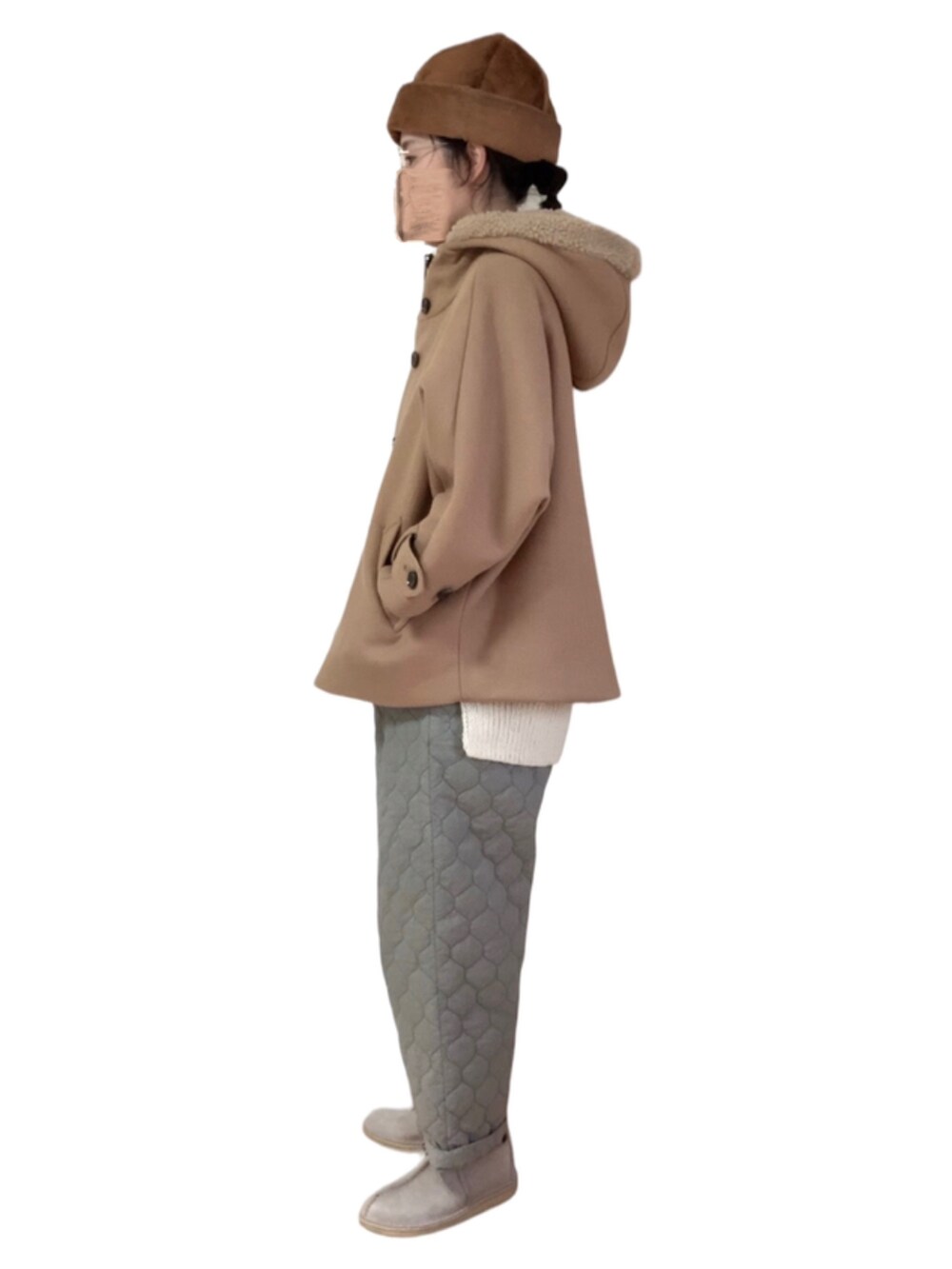 グレー系のパンツ、ブラウン系のその他シューズ、ホワイト系のベストを着用したレディースの冬コーディネートの2枚目の写真
