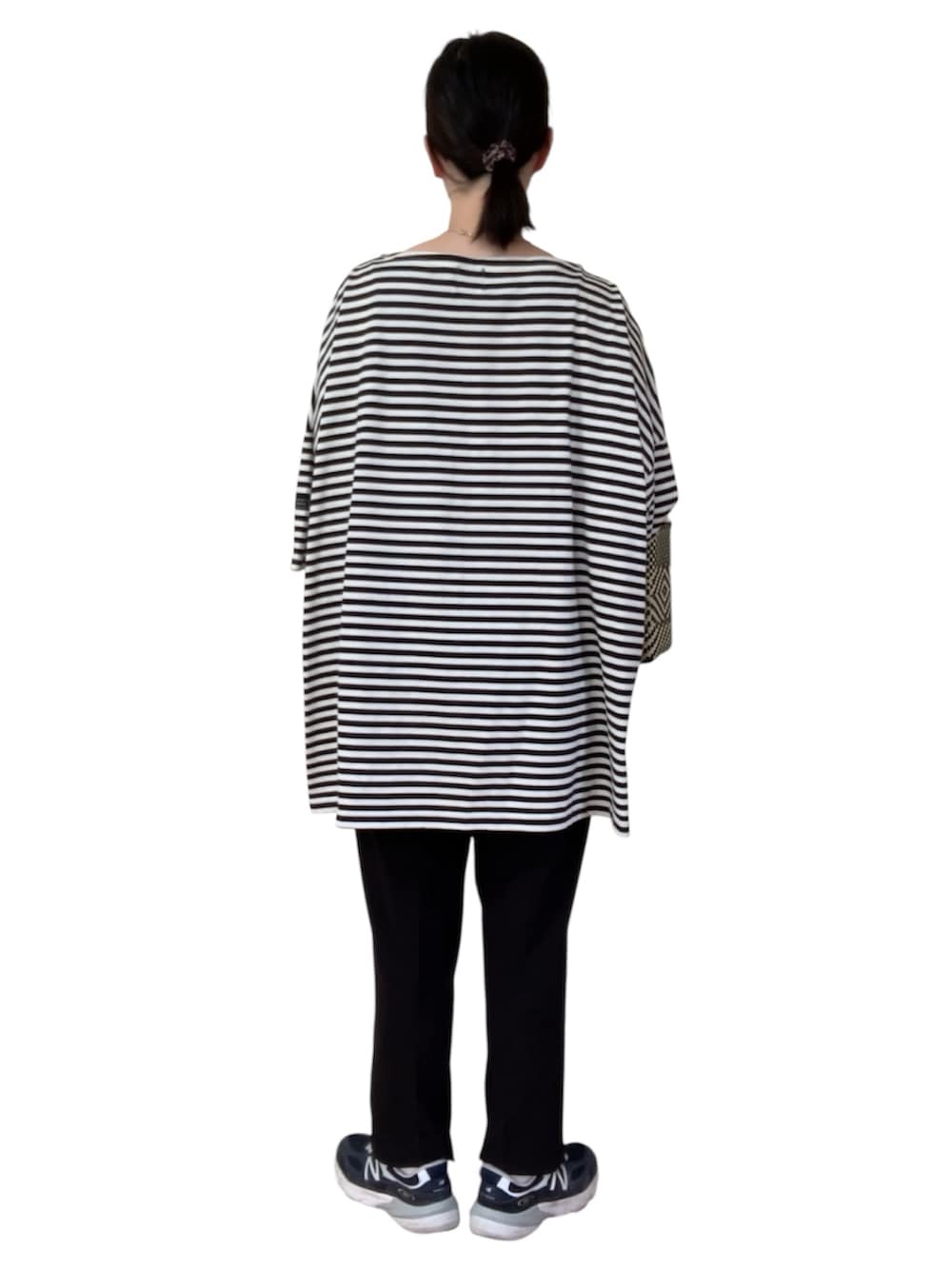 ブラック系のトートバッグ、ブラック系のその他パンツ、ブルー系のスニーカーを着用したレディースの秋コーディネートの3枚目の写真