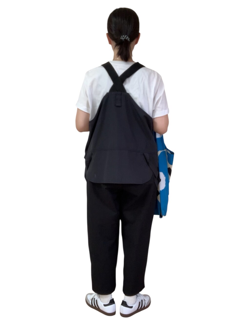 ホワイト系のTシャツ/カットソー、ブラック系のベスト、ホワイト系のスニーカーを着用したレディースの秋コーディネートの3枚目の写真