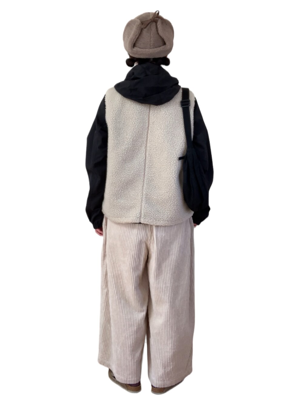 ブルー系のTシャツ/カットソー、ブラック系のマウンテンパーカー、ホワイト系のベストを着用したレディースの冬コーディネートの3枚目の写真