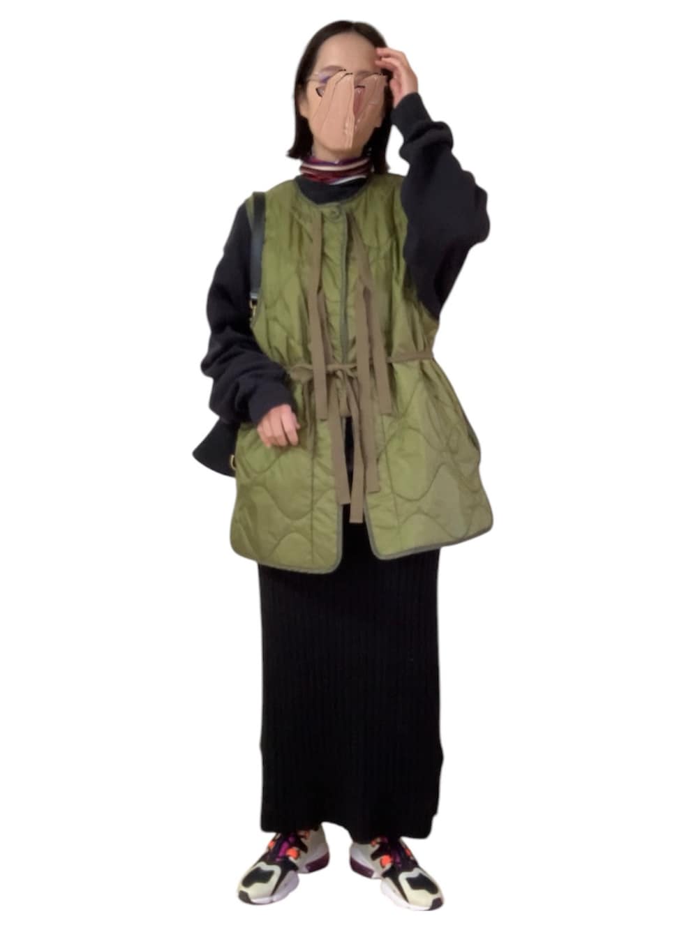 ブルー系のデニムジャケット、グリーン系のベスト、ブラック系のスカートを着用したレディースの冬コーディネートの2枚目の写真