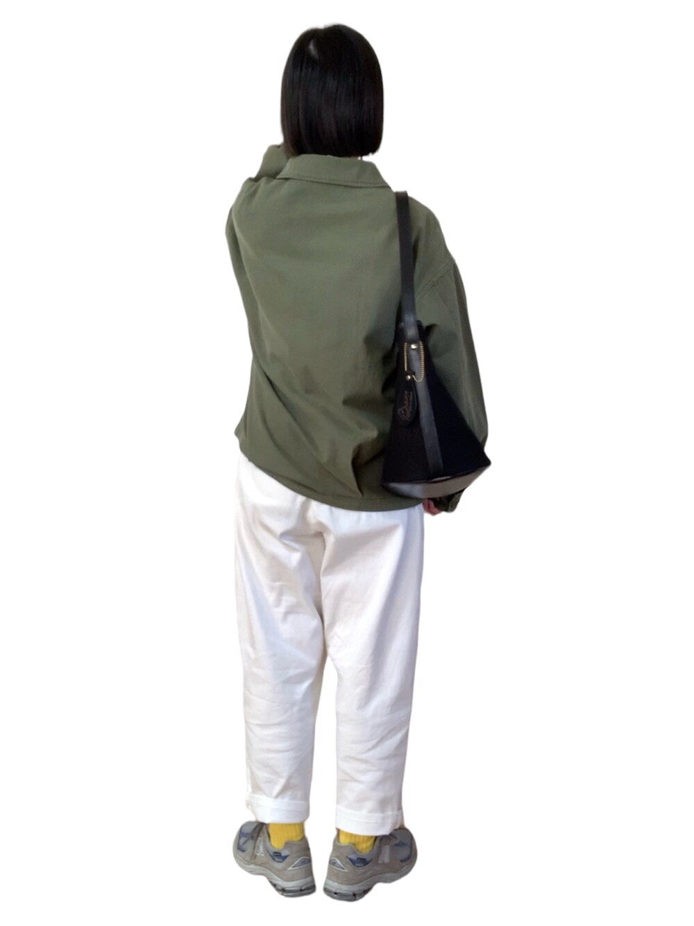 グリーン系のミリタリージャケット、ブラック系のショルダーバッグ、グレー系のスニーカーを着用したレディースの春コーディネートの2枚目の写真