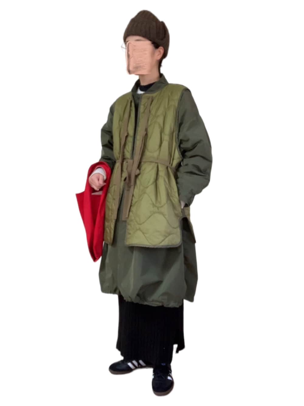 グリーン系のベスト、ブラック系のドレス、グリーン系のモッズコートを着用したレディースの冬コーディネートの3枚目の写真