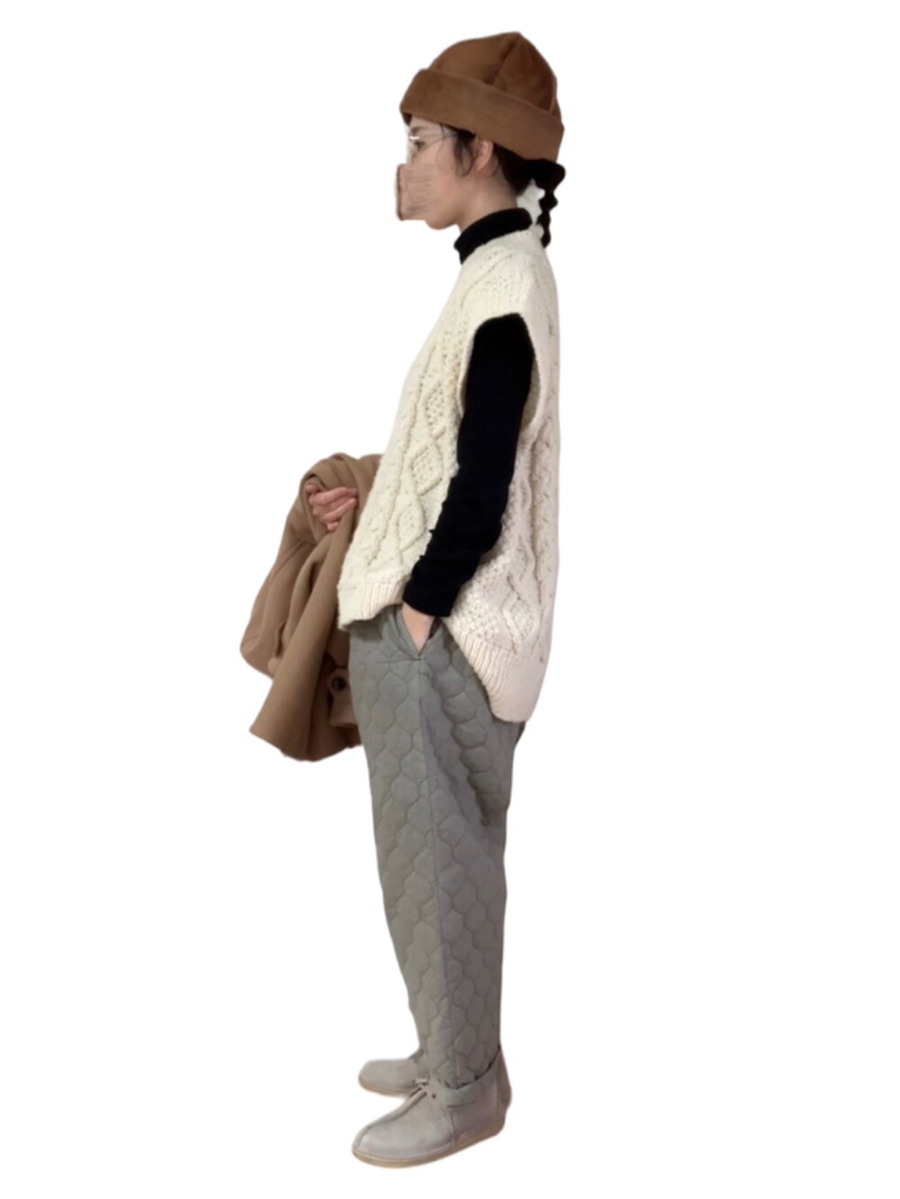 グレー系のパンツ、ブラウン系のその他シューズ、ホワイト系のベストを着用したレディースの冬コーディネートの4枚目の写真