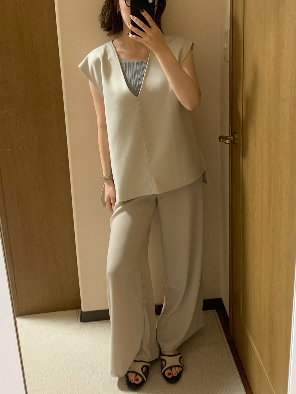 ブラック系のトップス、ホワイト系のベスト、ベージュ系のその他パンツを着用したレディースの夏コーディネートの2枚目の写真