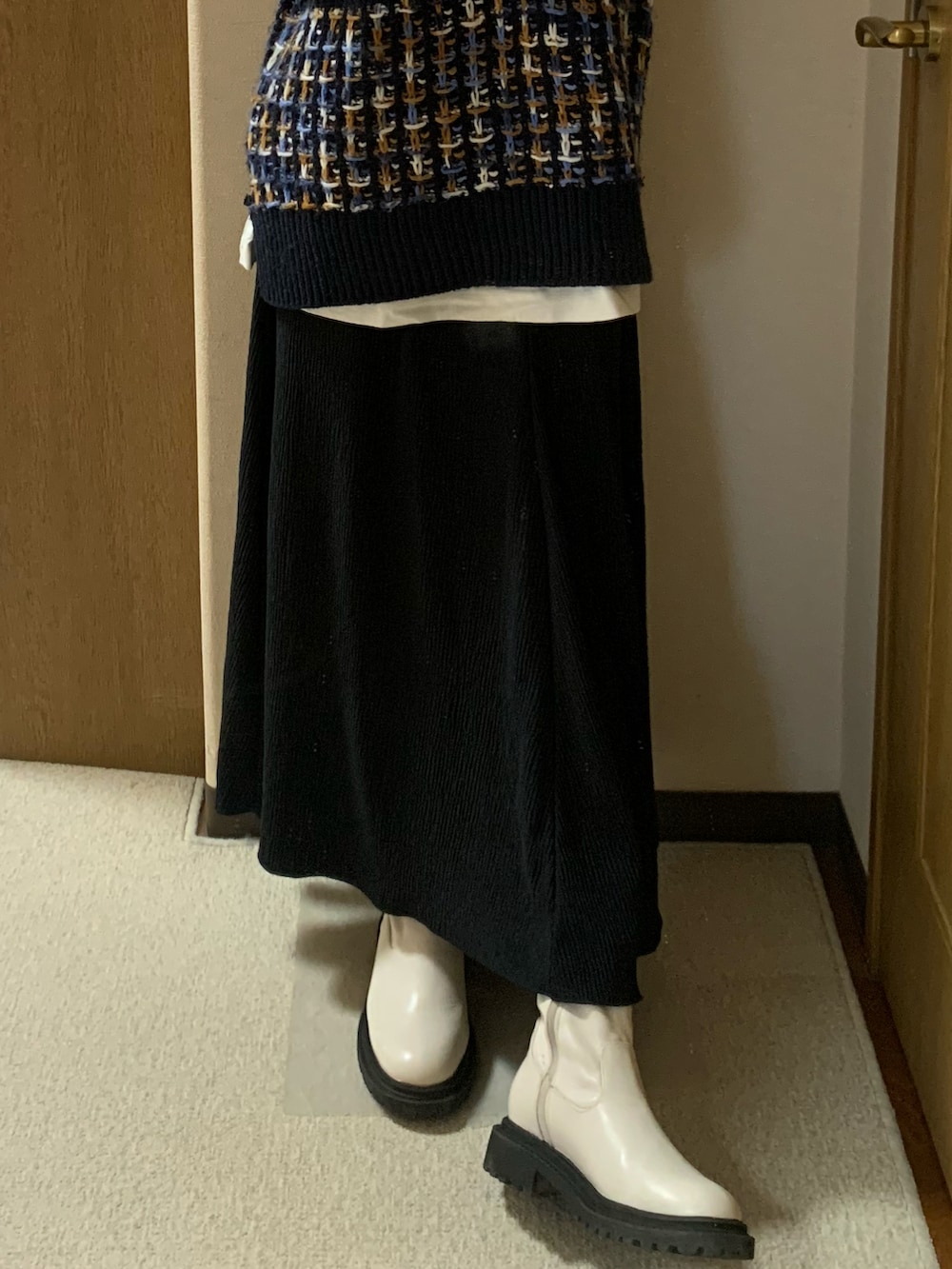 ブルー系のベスト、ホワイト系のTシャツ/カットソー、ブラック系のスカートを着用したレディースの秋コーディネートの4枚目の写真