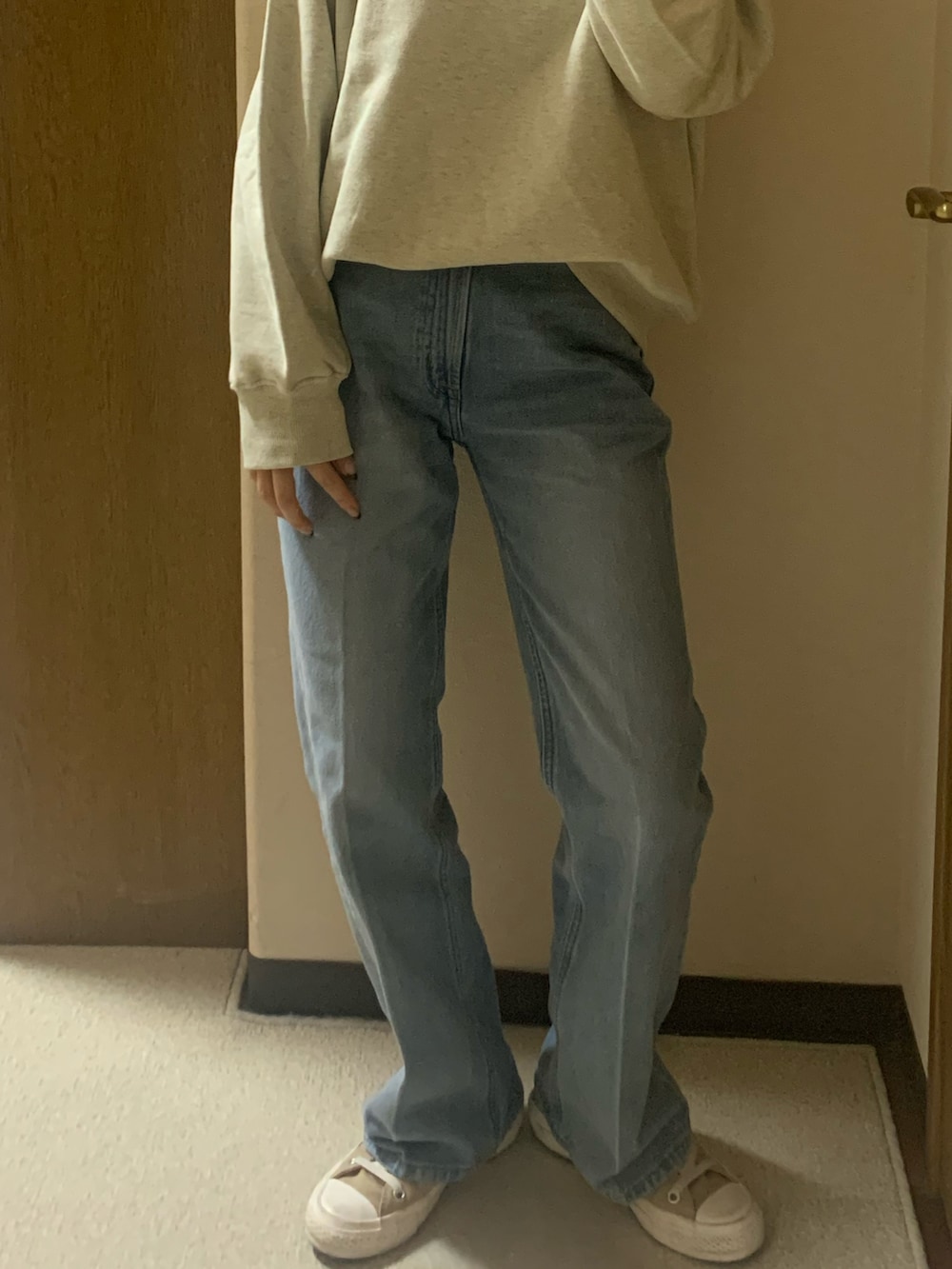 ベージュ系のスニーカー、ブルー系のデニムパンツ、ホワイト系のスウェットを着用したレディースの秋コーディネートの5枚目の写真