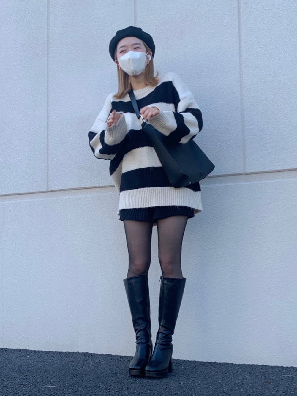 ブラック系のブーツ、ブラック系のバッグ、その他のニット/セーターを着用したレディースの秋コーディネートの2枚目の写真