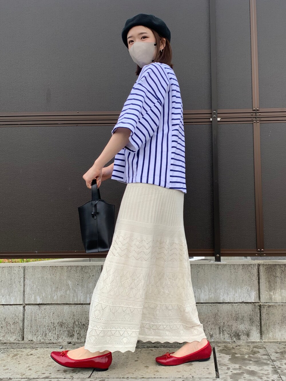 ブラック系のショルダーバッグ、ブラック系のバレエシューズ、ホワイト系のスカートを着用したレディースの夏コーディネートの3枚目の写真