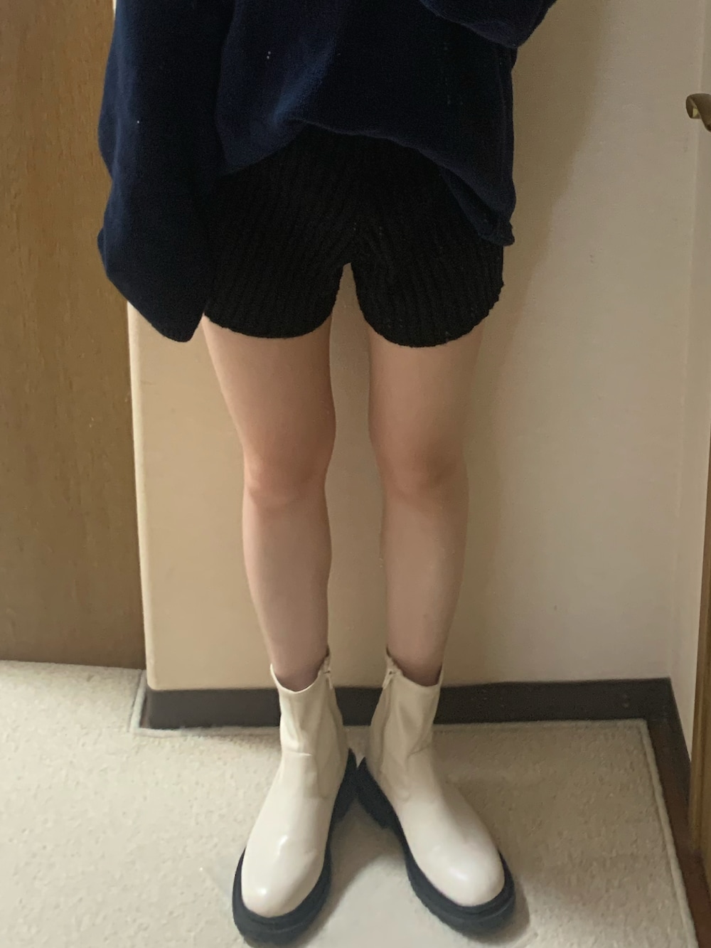 ホワイト系のブーツ、ブルー系のニット/セーター、ブラック系のトップスを着用したレディースの秋コーディネートの3枚目の写真