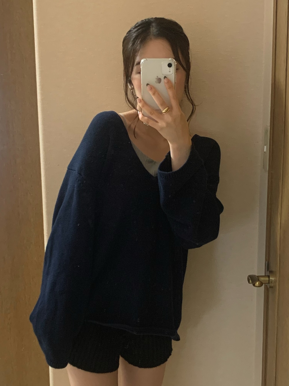 ホワイト系のブーツ、ブルー系のニット/セーター、ブラック系のトップスを着用したレディースの秋コーディネートの2枚目の写真