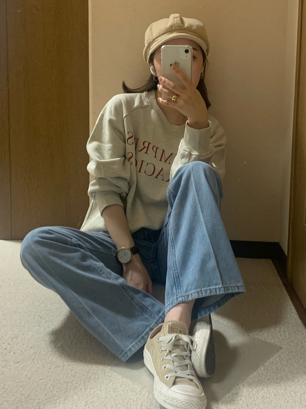 ベージュ系のスニーカー、ブルー系のデニムパンツ、ホワイト系のスウェットを着用したレディースの秋コーディネートの3枚目の写真