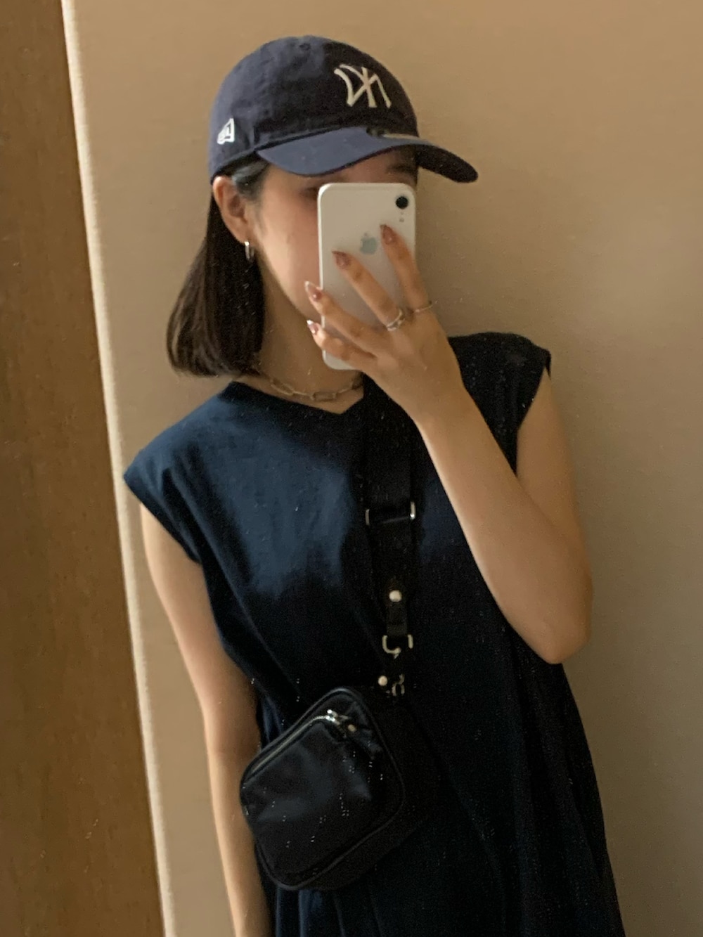 ブルー系のワンピース、シルバー系のサンダル、ブルー系のキャップを着用したレディースの夏コーディネートの2枚目の写真