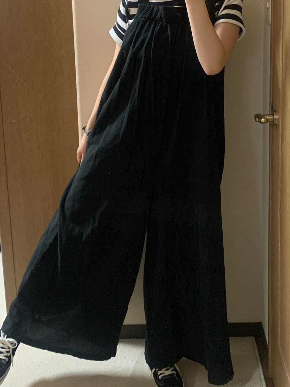 ブラック系のワンピース、ブラック系のTシャツ/カットソー、ブラック系のスニーカーを着用したレディースの秋コーディネートの3枚目の写真