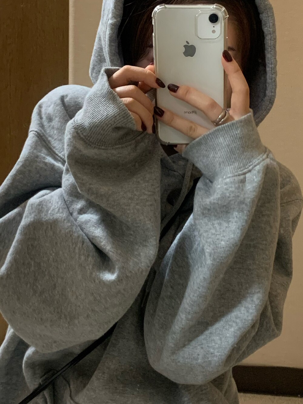 ブラック系のショルダーバッグ、ホワイト系のスカート、グレー系のパーカーを着用したレディースの秋コーディネートの4枚目の写真