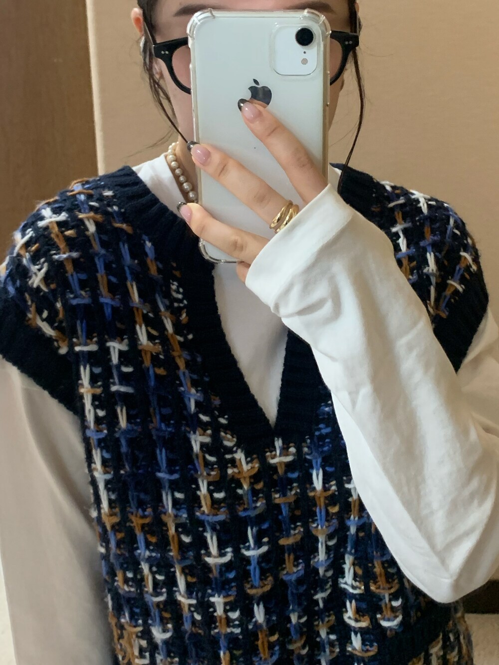 ブルー系のベスト、ホワイト系のTシャツ/カットソー、ブラック系のスカートを着用したレディースの秋コーディネートの5枚目の写真