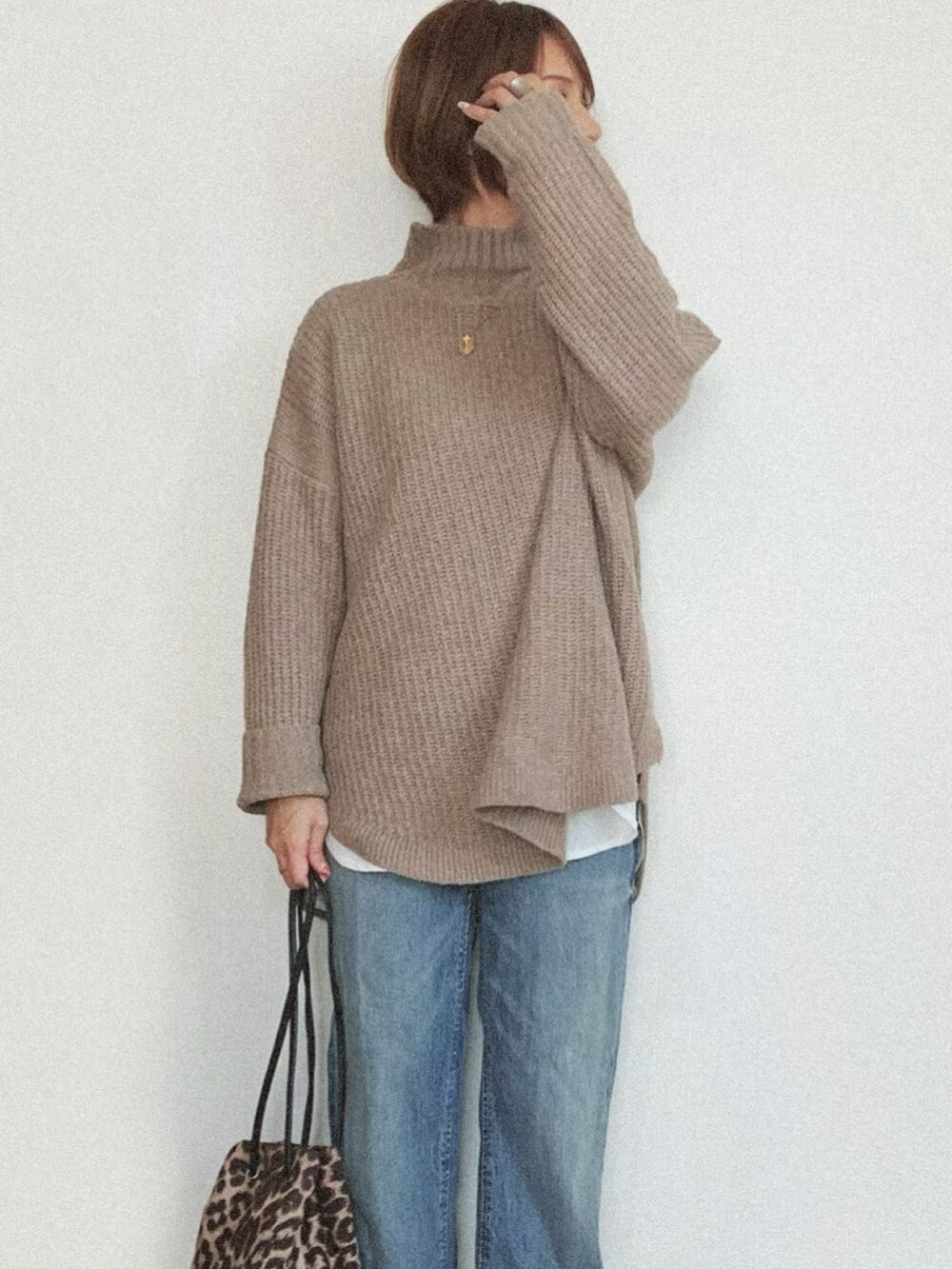 ブラウン系のニット/セーター、ブラック系のノーカラージャケット、ブラウン系のバッグを着用したレディースの冬コーディネートの2枚目の写真