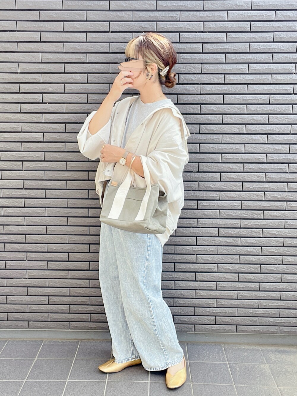 ホワイト系のマウンテンパーカー、グレー系のTシャツ/カットソー、ブルー系のデニムパンツを着用したレディースの春コーディネートの4枚目の写真