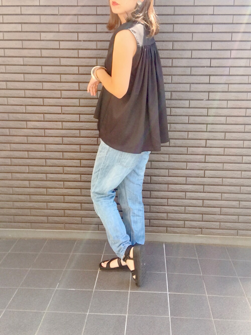 ブラック系のシャツ/ブラウス、ブルー系のデニムパンツ、ブラック系のサンダルを着用したレディースの夏コーディネートの3枚目の写真