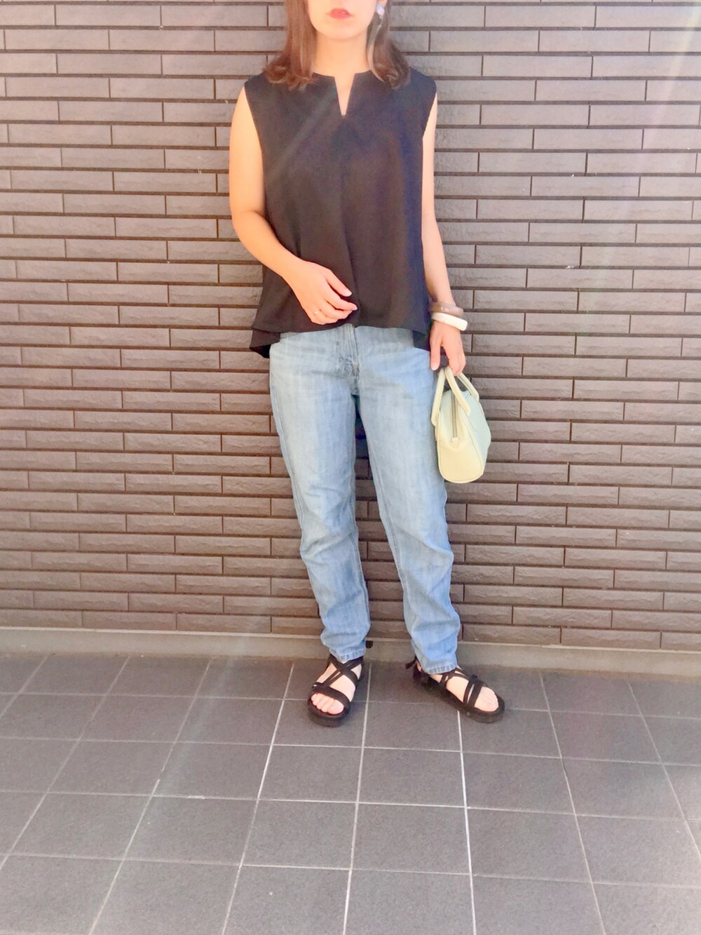 ブラック系のシャツ/ブラウス、ブルー系のデニムパンツ、ブラック系のサンダルを着用したレディースの夏コーディネートの2枚目の写真
