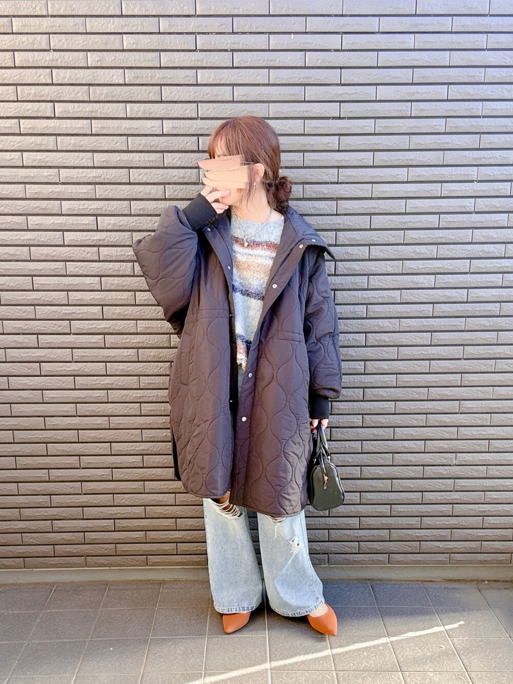 ブラック系のダウンジャケット/コート、ブルー系のニット/セーター、ブルー系のデニムパンツを着用したレディースの冬コーディネートの3枚目の写真